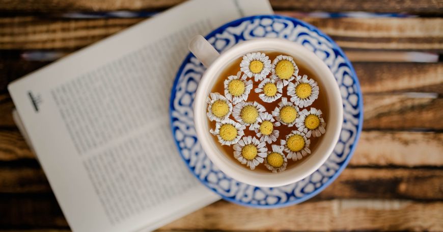 Tasse mit Kamillenblüten, die helfen, Cortisol auf natürliche Weise zu senken