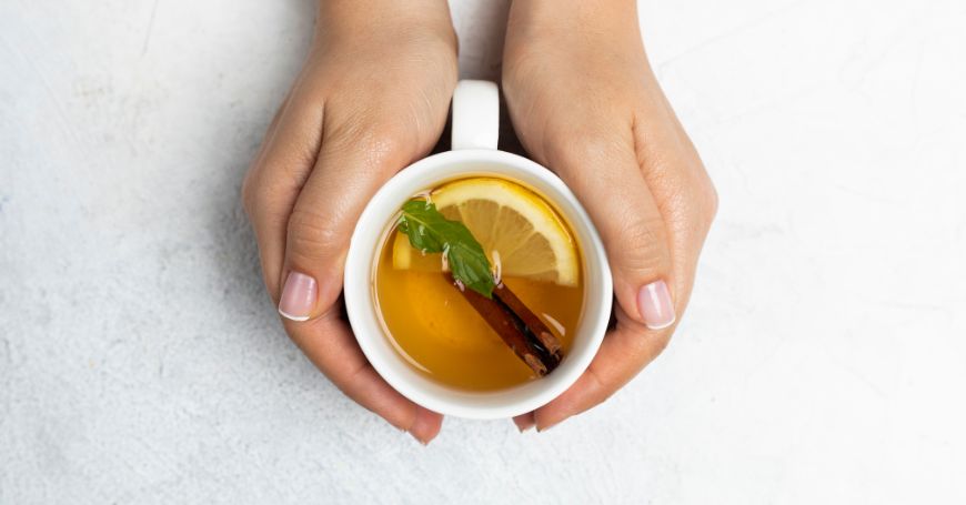 mani stringono una tazza di tisana antinfiammatoria